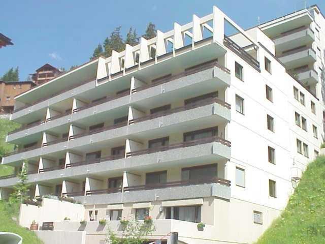 een groot wit appartementencomplex met een witte leuning bij Casa Irmella 16 in Arosa