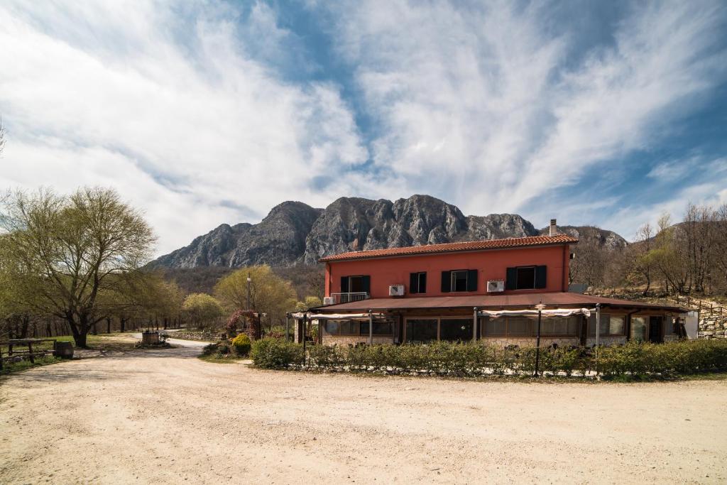 ein Haus auf einer unbefestigten Straße mit einem Berg im Hintergrund in der Unterkunft Locanda Belvedere Da Stefano in Rocchetta a Volturno