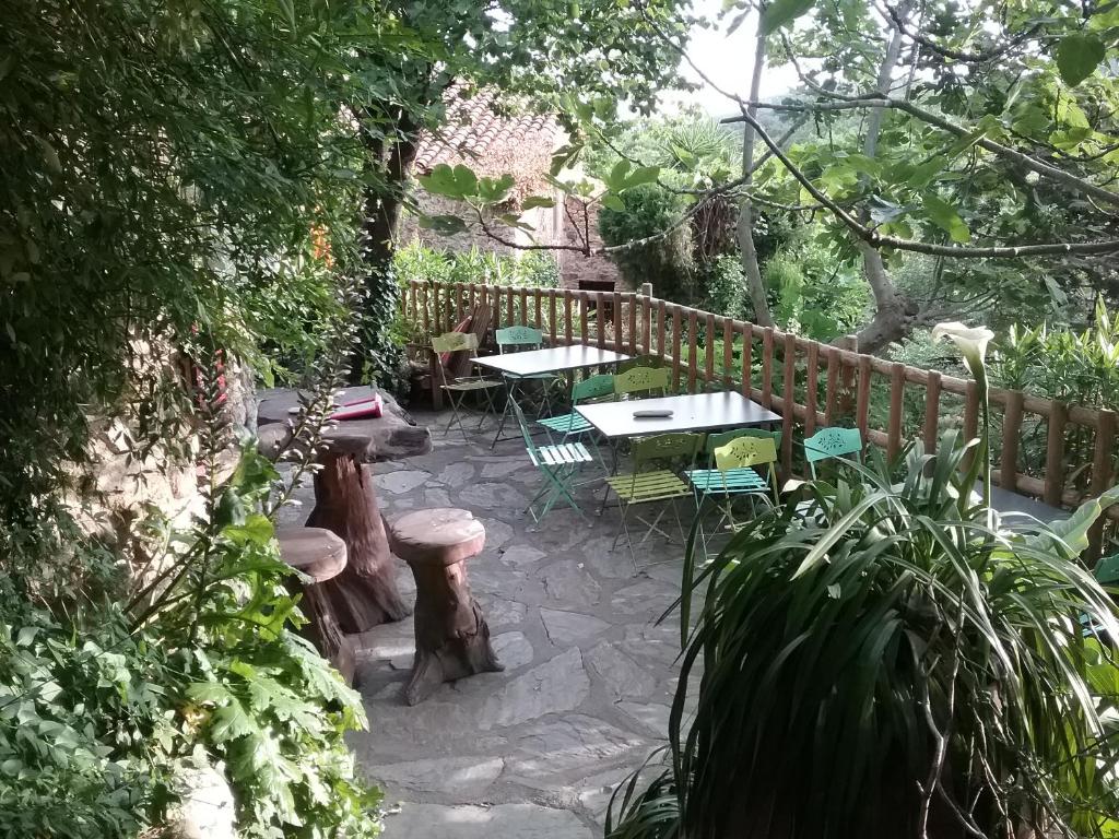 a patio with tables and chairs and a wooden fence at La Figuera in Castelnou