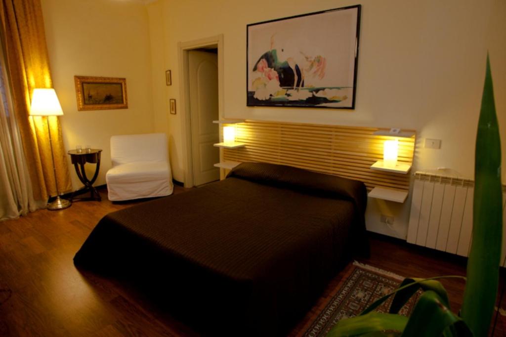 1 dormitorio con 1 cama y 1 silla blanca en Affittacamere Villa Wilson en Roma