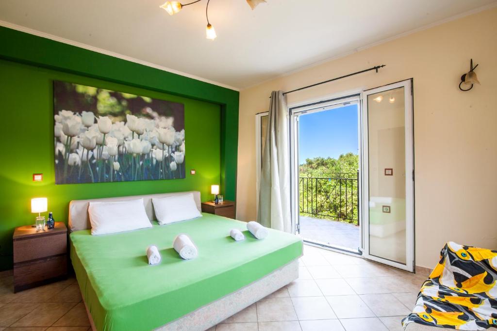 una camera verde con un letto e una porta scorrevole in vetro di Harmony Marathias luxury apartment a Marathias