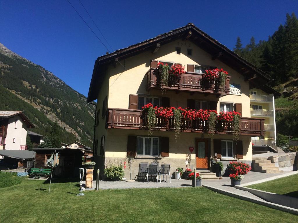 um edifício com caixas de flores e varandas em Apartment Enzian em Saas-Grund