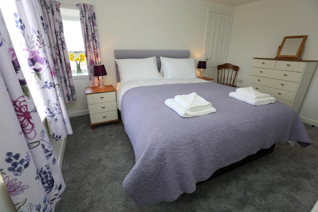 a bedroom with a bed with two towels on it at Chapman's in Stornoway