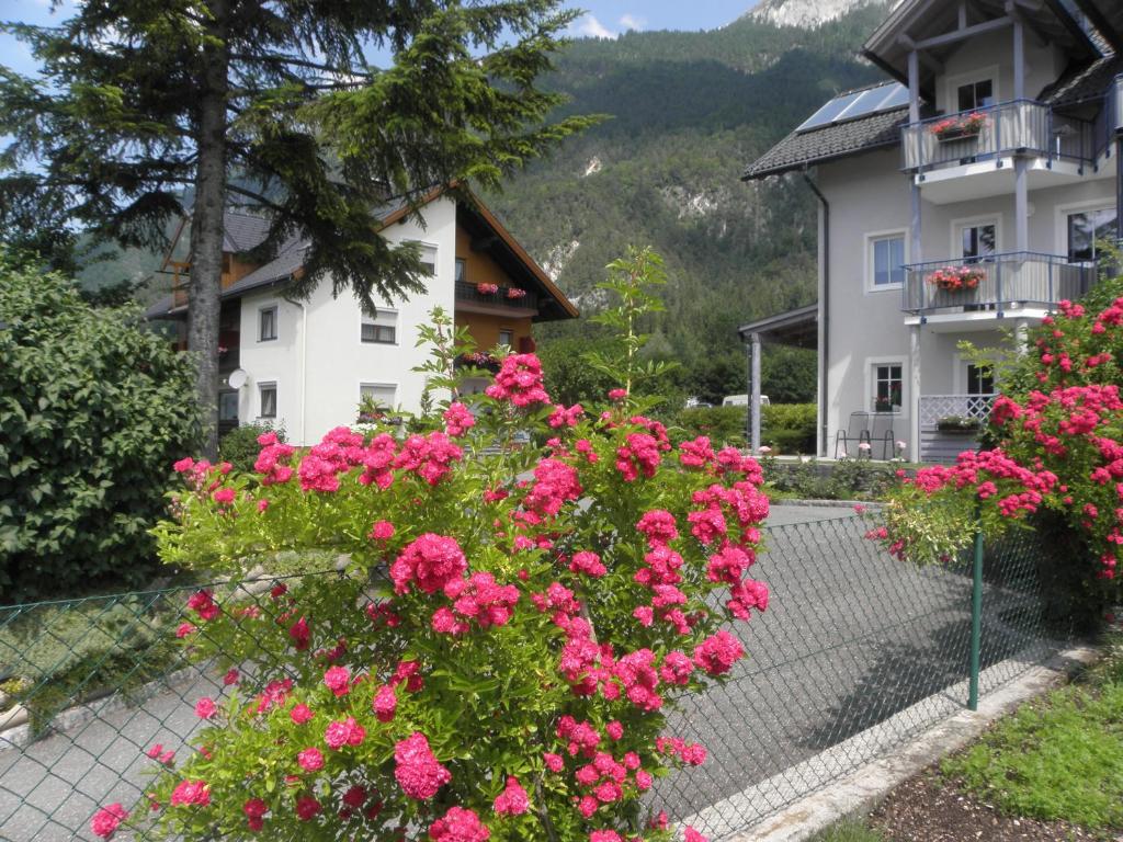 a house with pink flowers in front of a fence at Ferienwohnungen-Pension Kraker in Lake Pressegg