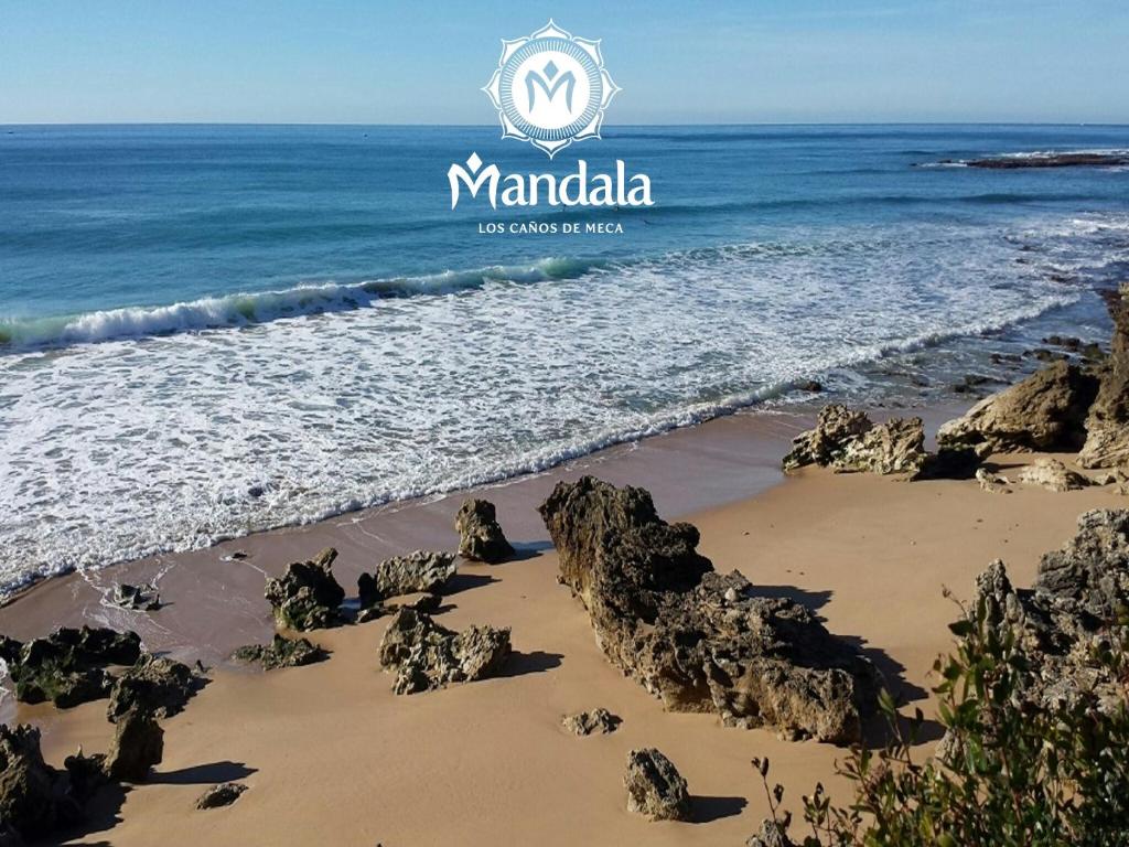 a beach with rocks in the sand and the ocean at Mandala Bungalows - Adults Only in Los Caños de Meca
