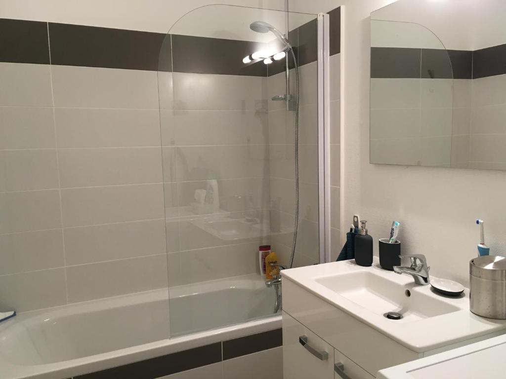 een badkamer met een wastafel, een douche en een bad bij "La Mercerie" in La Rochelle