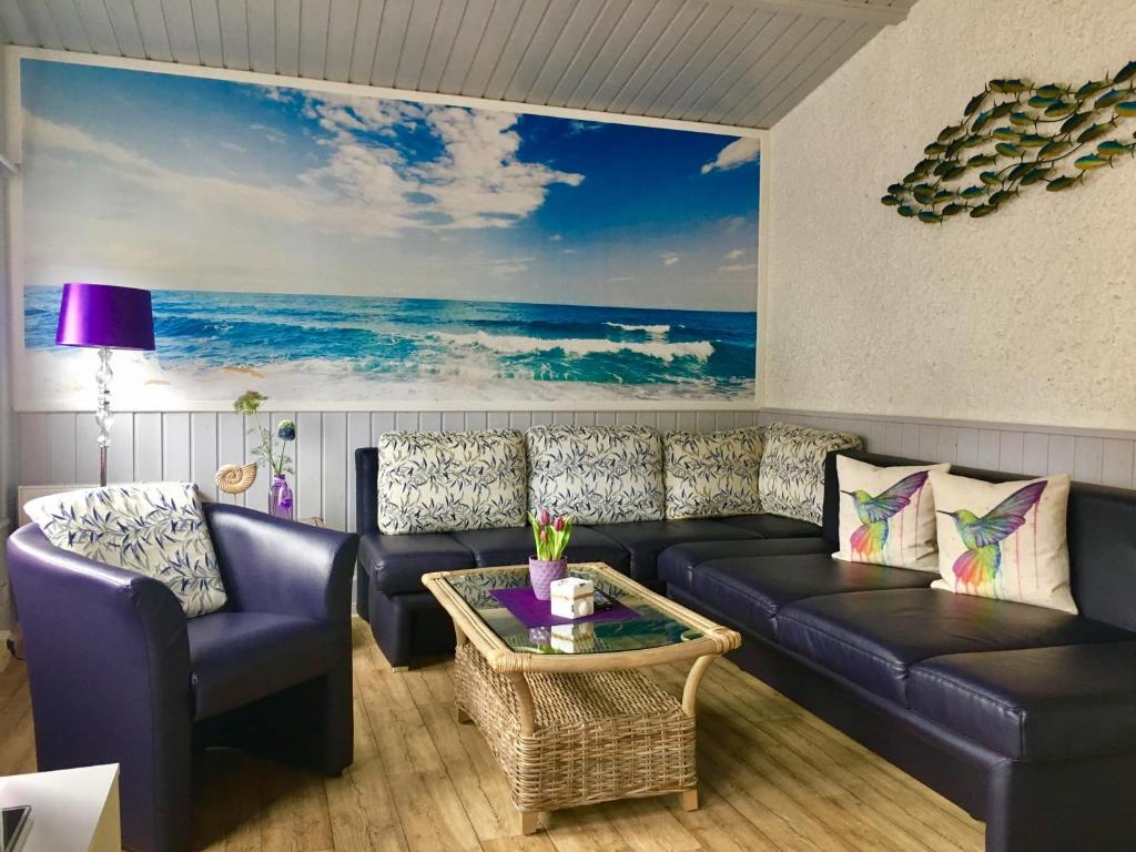 a living room with a couch and a painting of the ocean at Pension Inselparadies Zingst in Zingst