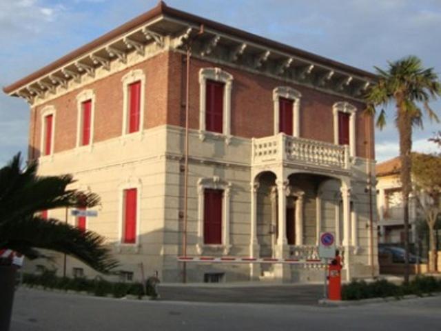 ein großes Backsteingebäude mit Balkon auf einer Straße in der Unterkunft Villa Marietta in Civitanova Marche