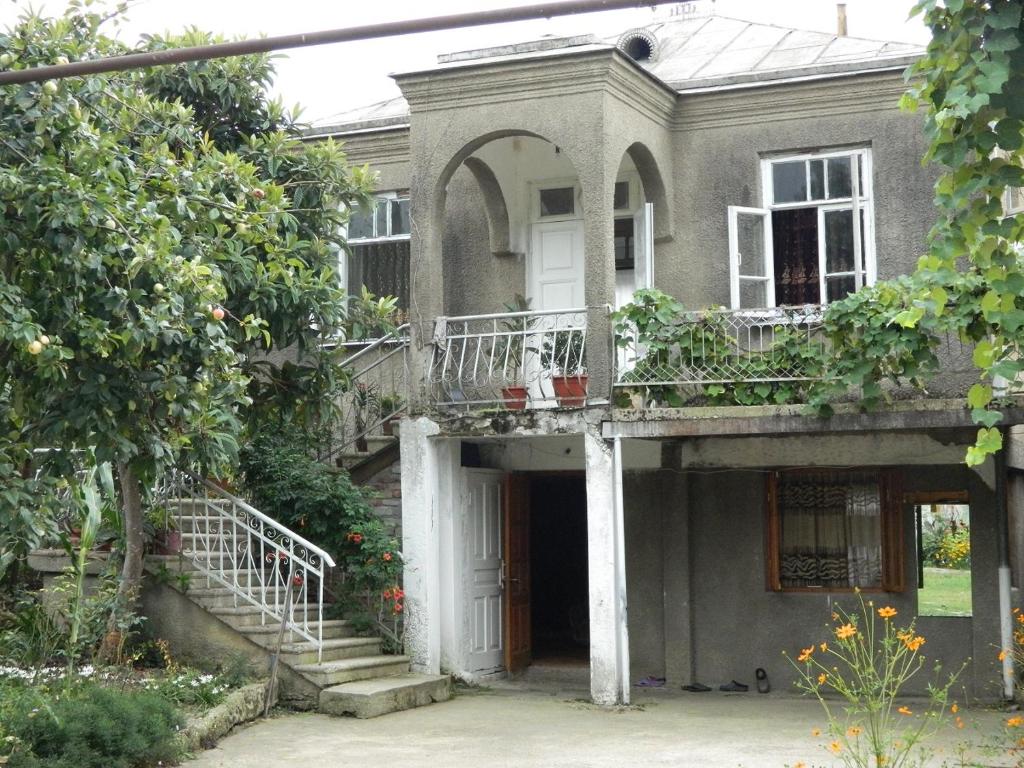 una vecchia casa con portico e balcone di Guest house na Myasnikova Diamond a Novy Afon