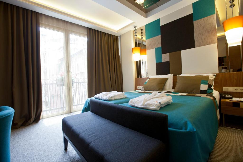 a hotel room with a bed and a large window at Collage Taksim Hotel in Istanbul