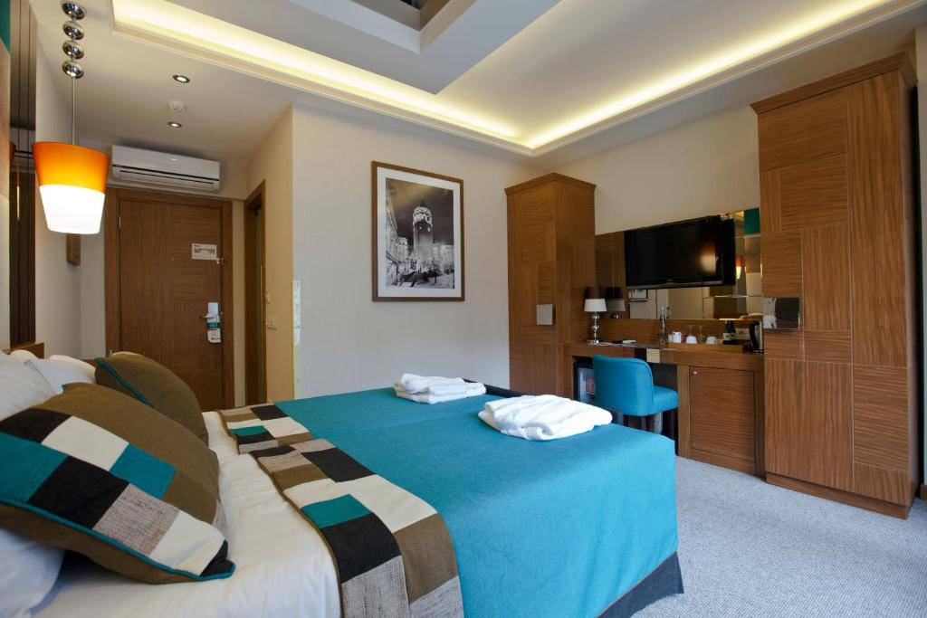 um quarto de hotel com uma cama e uma televisão em Collage Taksim Hotel em Istambul