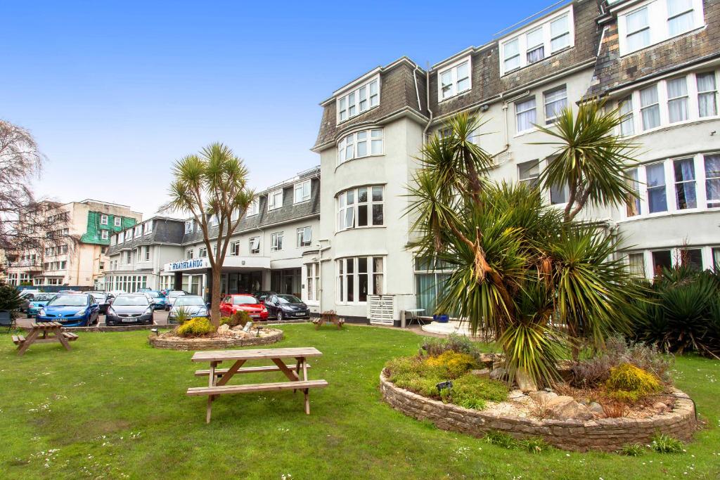 
a park bench in front of a large building at Heathlands Hotel in Bournemouth
