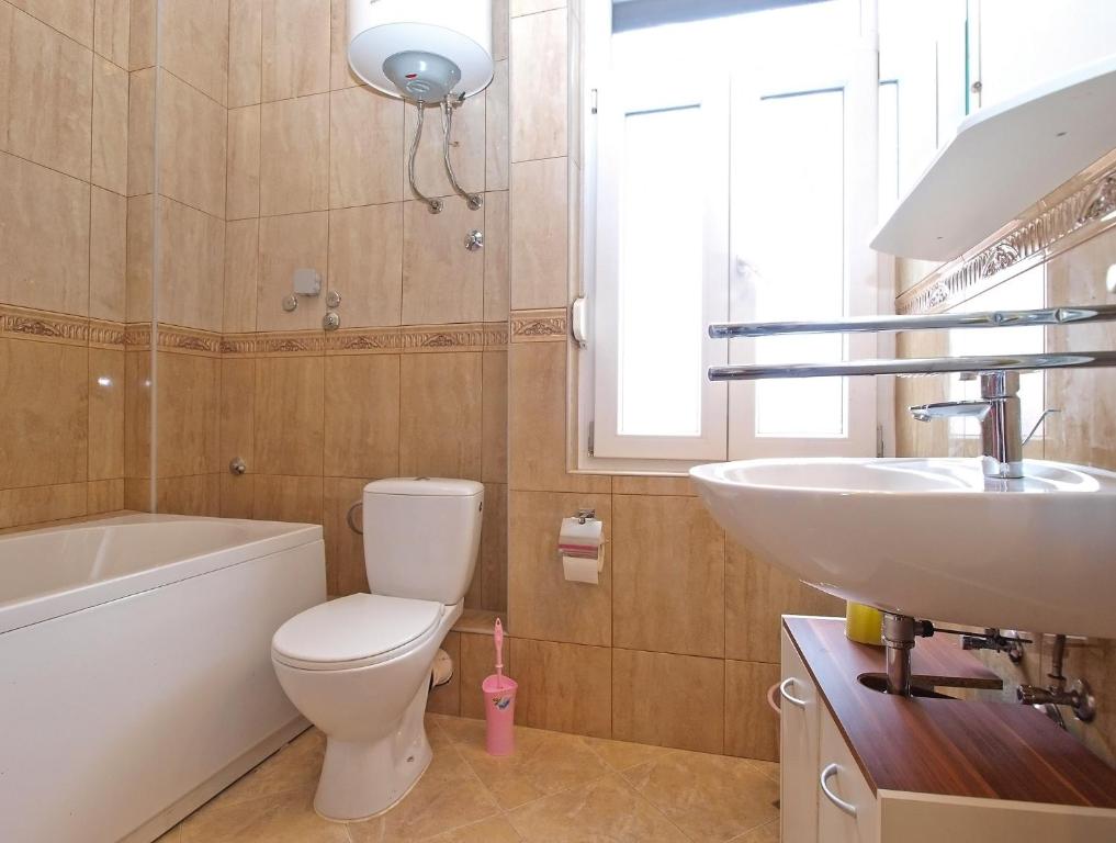 Łazienka z białą toaletą i umywalką w obiekcie Apartments Paulina 1347 w Puli