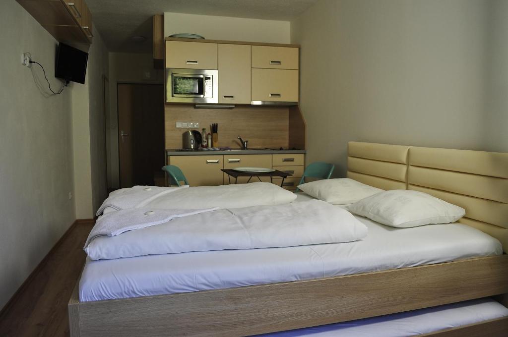 a large bed in a room with a kitchen at Apartman 4 Vsemina Valassko in Všemina