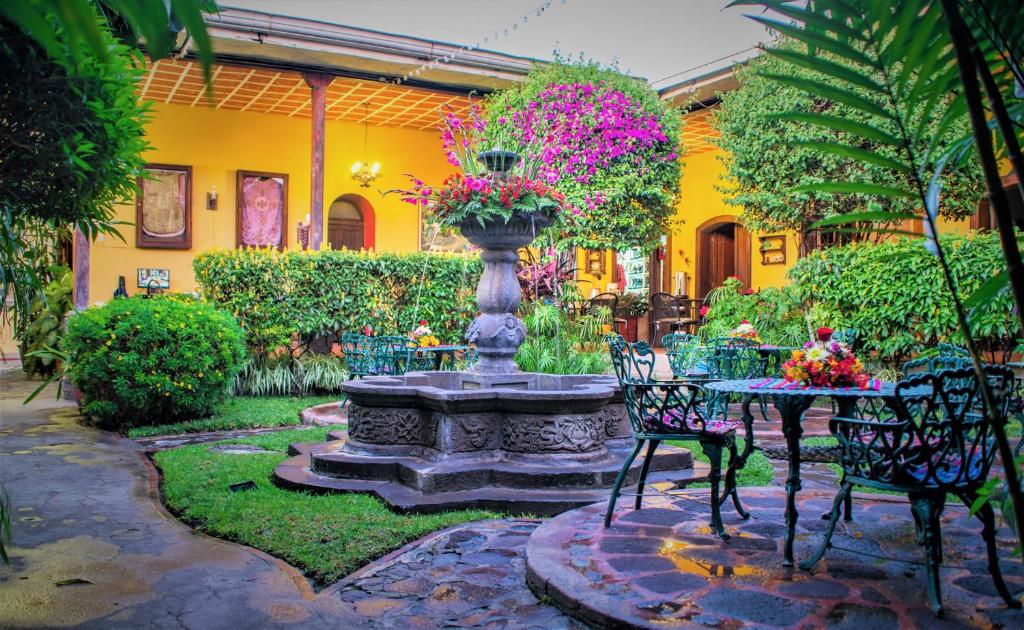 a garden with a fountain and a table and chairs at Hotel Casa Antigua by AHS in Antigua Guatemala