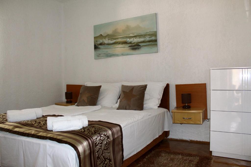 a bedroom with two beds and a painting on the wall at Apartments Nadia2 in Baška