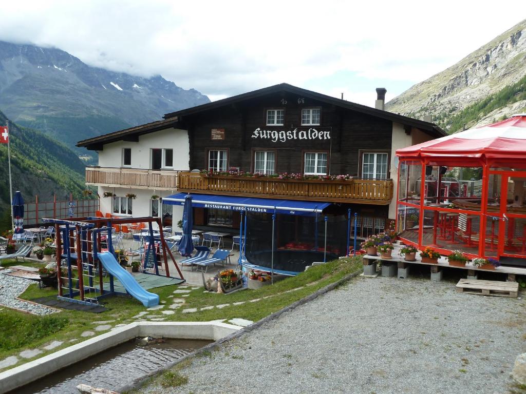 un grande edificio con parco giochi di fronte di Berghotel Furggstalden a Saas-Almagell