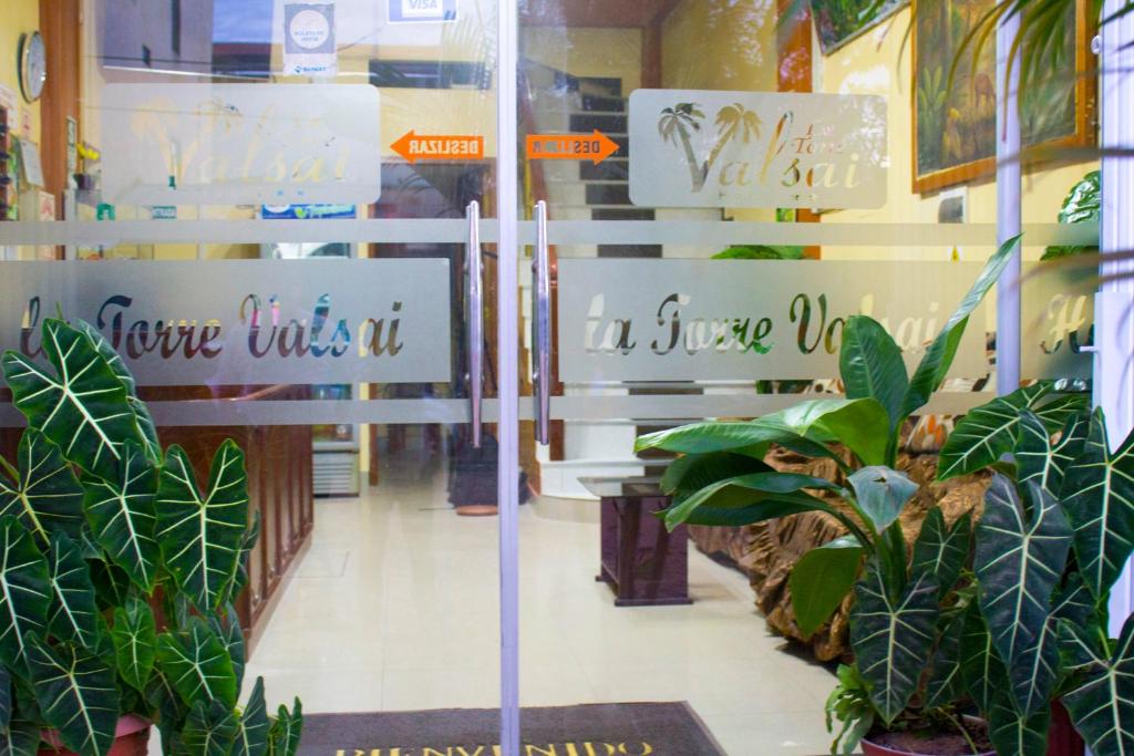 Una ventana de una tienda con plantas. en La Torre Valsai, en Puerto Maldonado