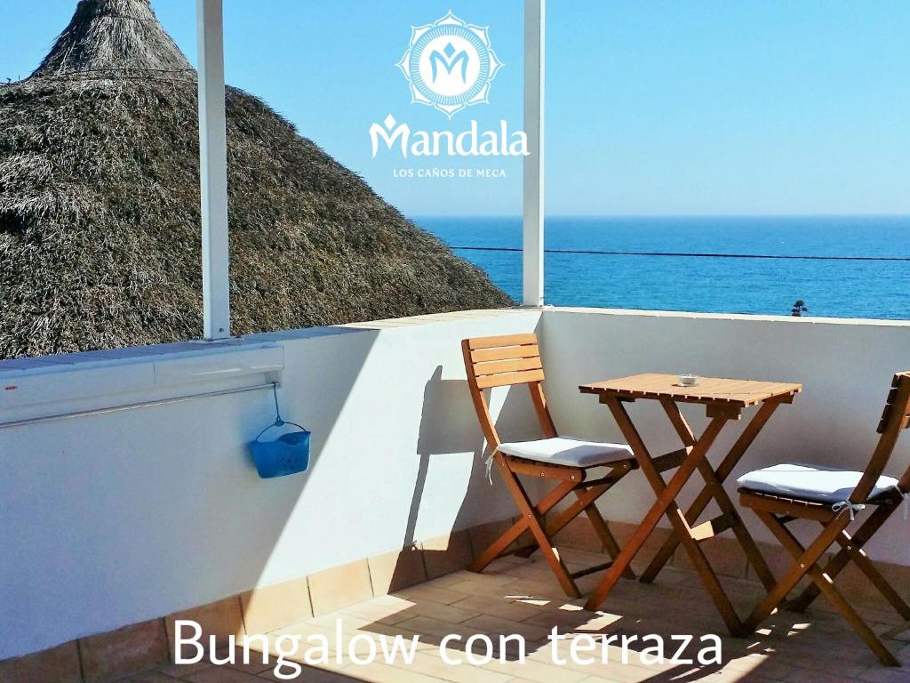 two chairs and a table on a balcony overlooking the ocean at Mandala Bungalows - Adults Only in Los Caños de Meca