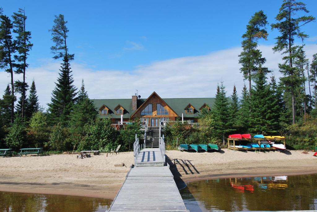 una casa en una playa con un muelle de madera en Camp Taureau - Altaï Canada, en Saint-Michel-des-Saints