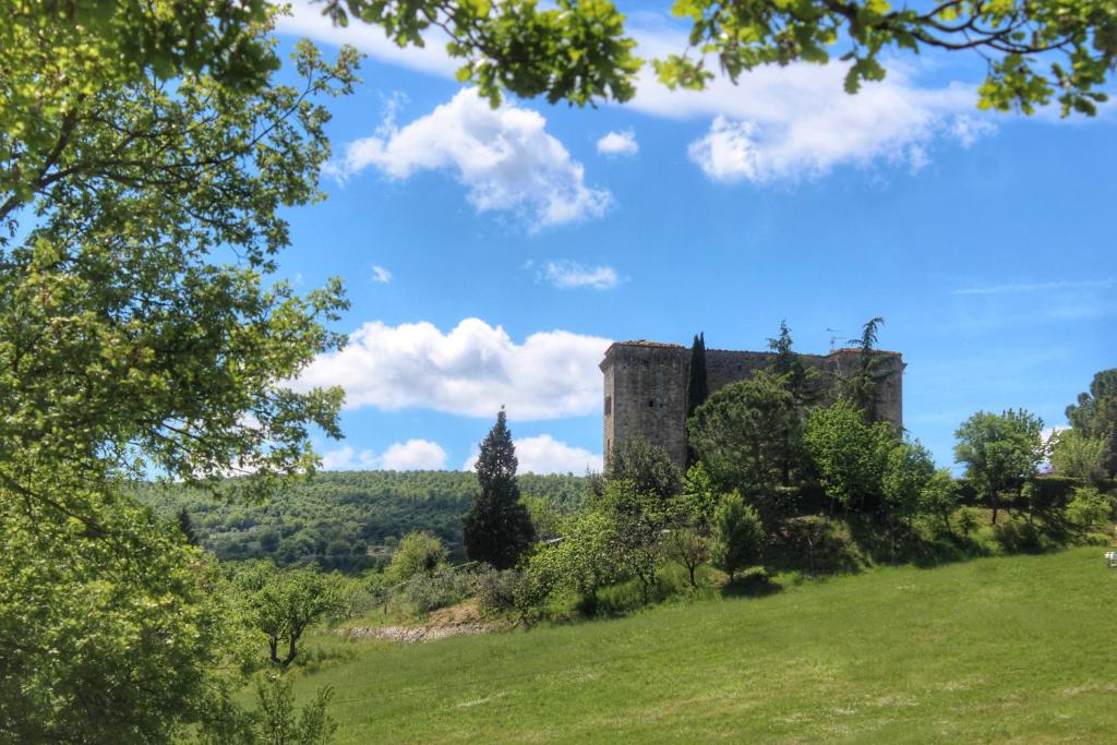 un castillo en una colina con un campo verde en Agriturismo Castello Di Belforte, en Todi