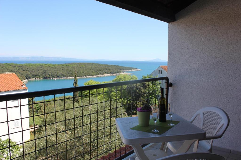 a table on a balcony with a view of the water at Apartments Unija Duga Uvala in Krnica