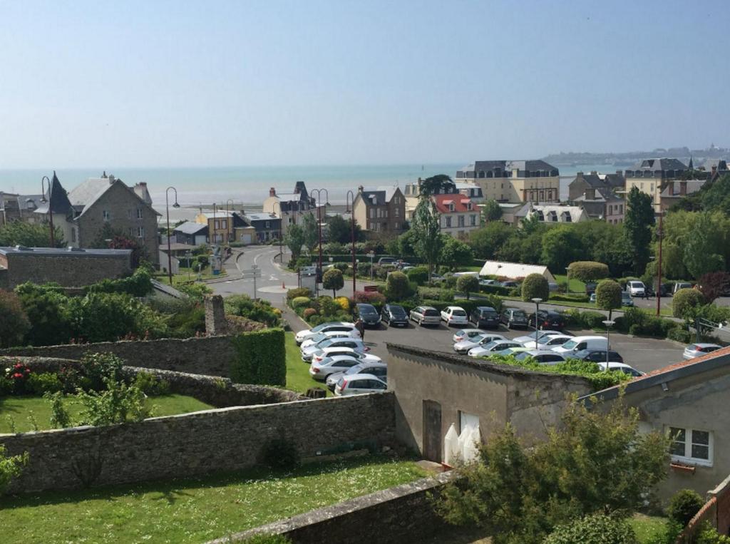 une ville avec des voitures garées dans un parking dans l'établissement Vue magnifique sur mer, à Saint-Pair-sur-Mer