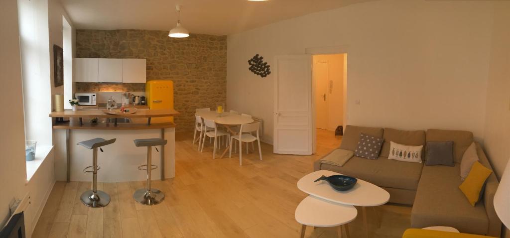 ein Wohnzimmer mit einem Sofa und einem Tisch sowie eine Küche in der Unterkunft Le Wim'Heureux in Wimereux