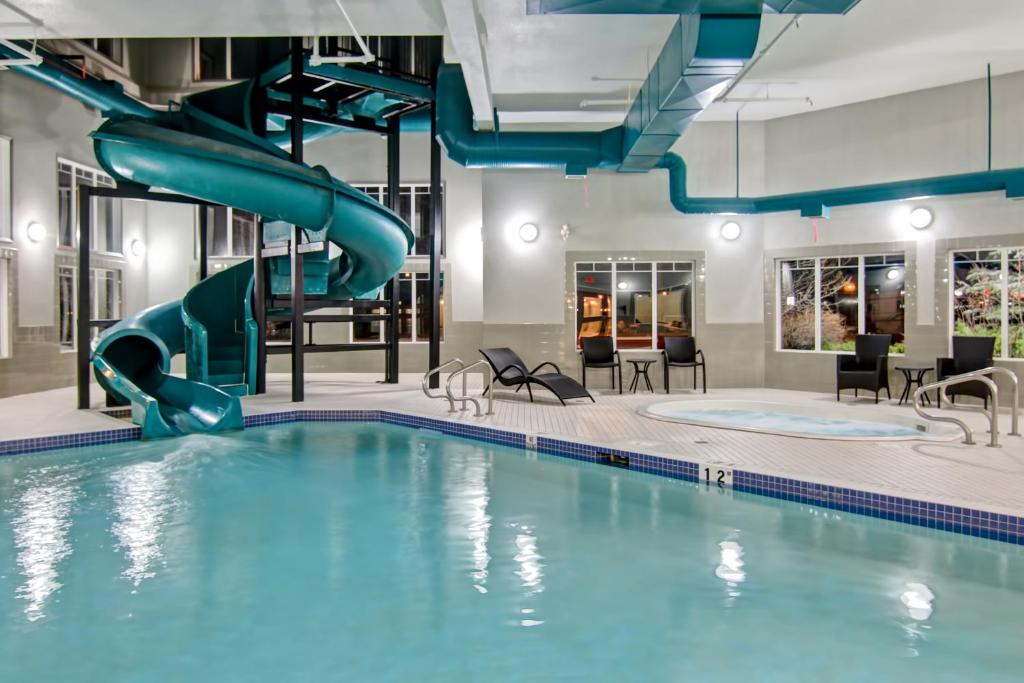 a swimming pool with a pool table and chairs at Canalta Brooks in Brooks