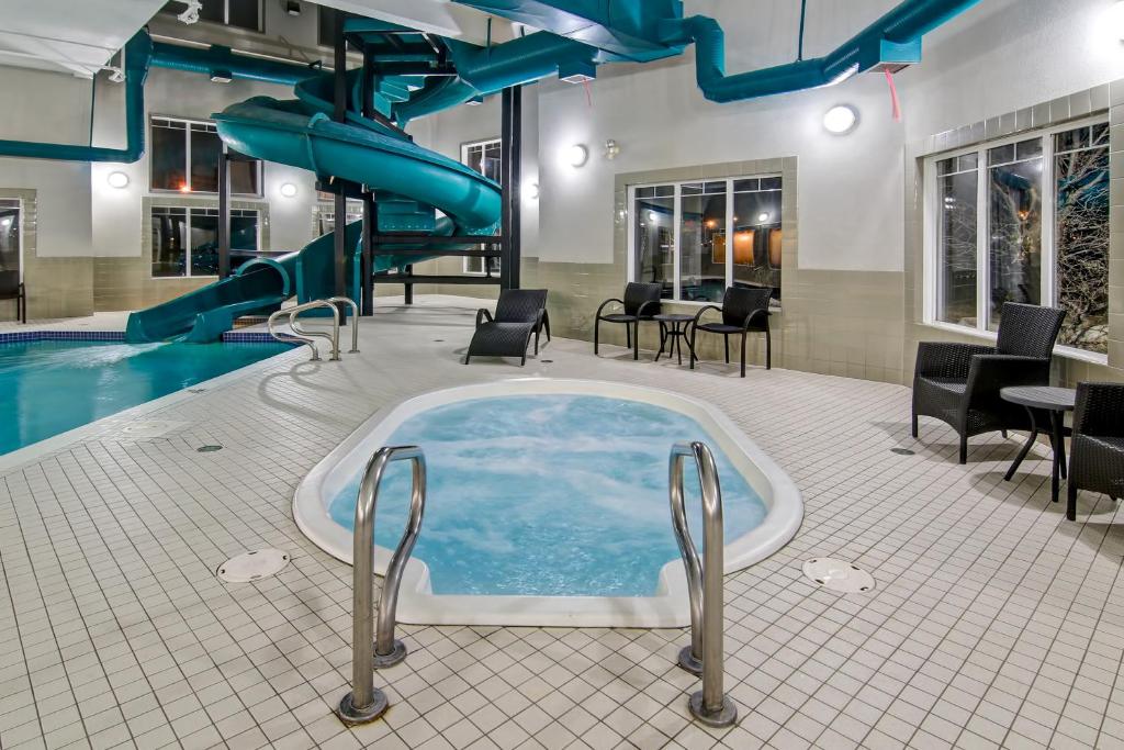 een jacuzzi in een zwembad met glijbaan bij Canalta Brooks in Brooks