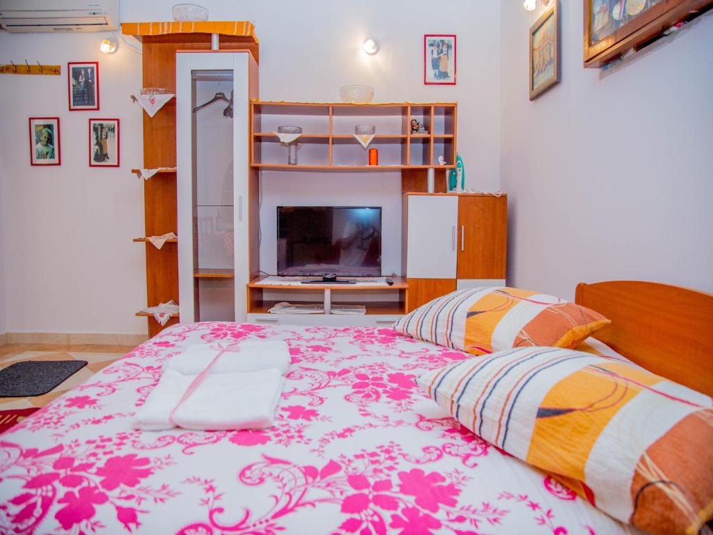 a bedroom with a large bed and a tv at Guest House Jeljenic in Dubrovnik