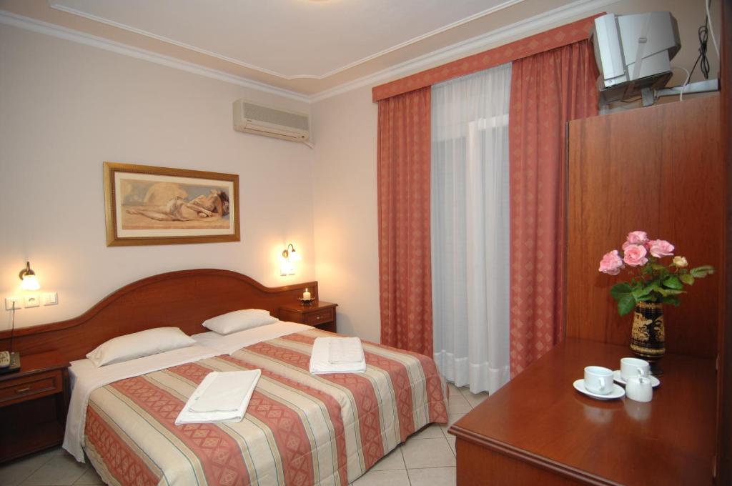 ein Hotelzimmer mit einem Bett und einem Tisch mit einem Schreibtisch in der Unterkunft Kalipso in Paralia Katerinis