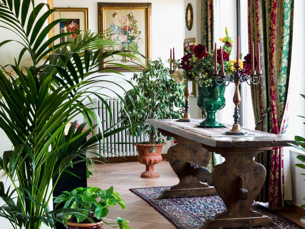 a room with plants and a table with a vase on it at Hotel Sirius in Taormina