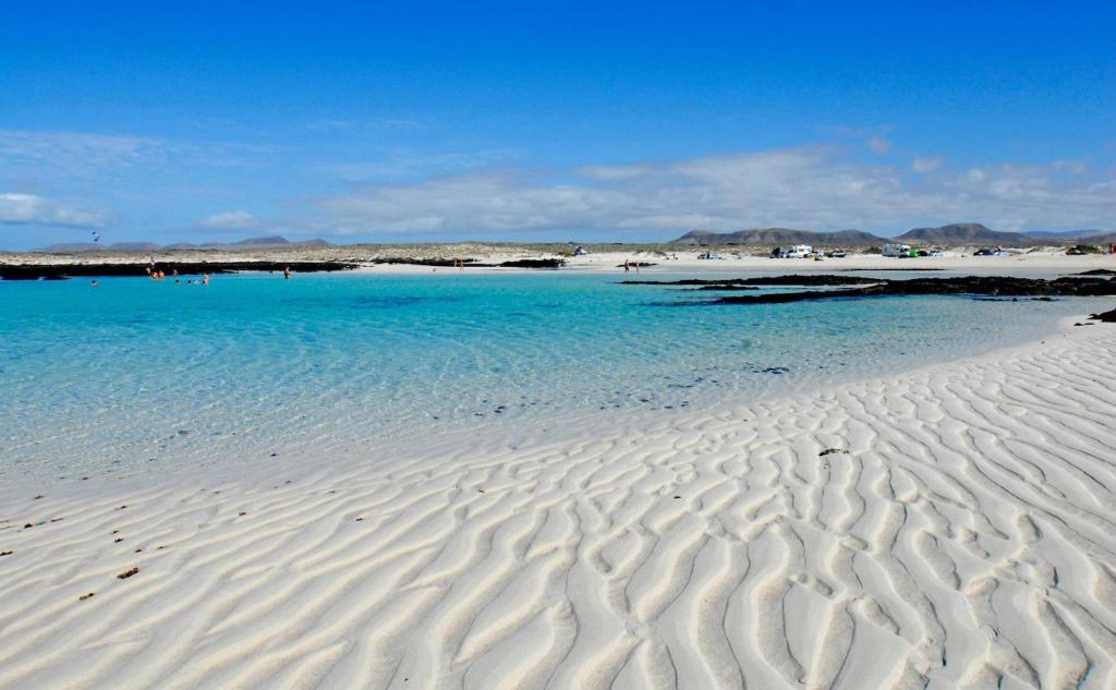 une plage d'eau bleue et de ruisseaux dans le sable dans l'établissement Casa Paradise, à El Cotillo