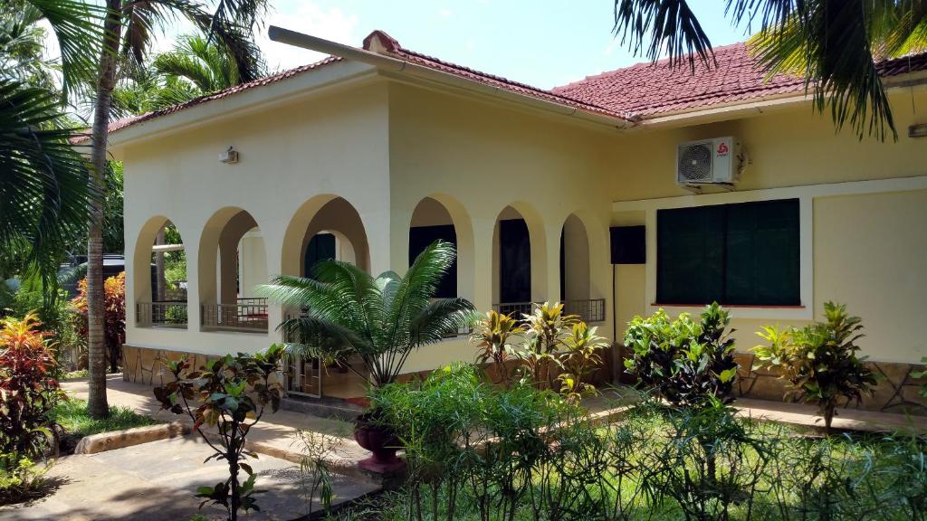 a house with trees and plants in front of it at Jamboland-Diani in Diani Beach