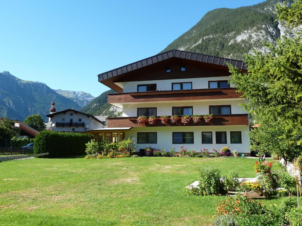 una casa en las montañas con un patio en Gästehaus Frischhut, en Nassereith
