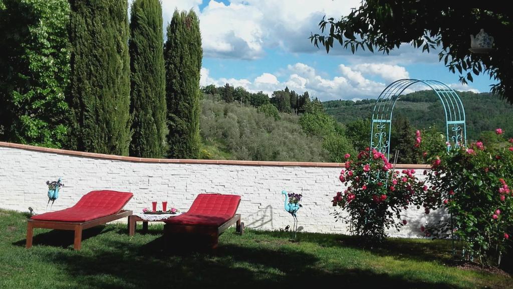 two red chairs and a table in a yard at La Luna in Impruneta