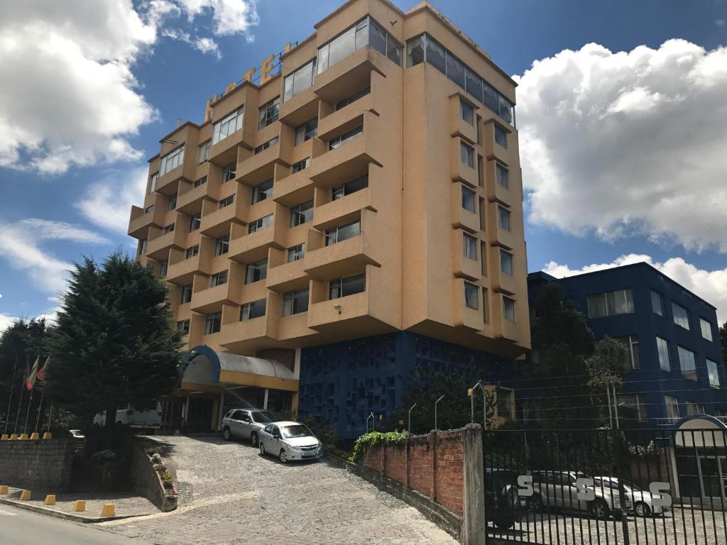 a building with cars parked in front of it at Hotel Savoy Inn in Quito