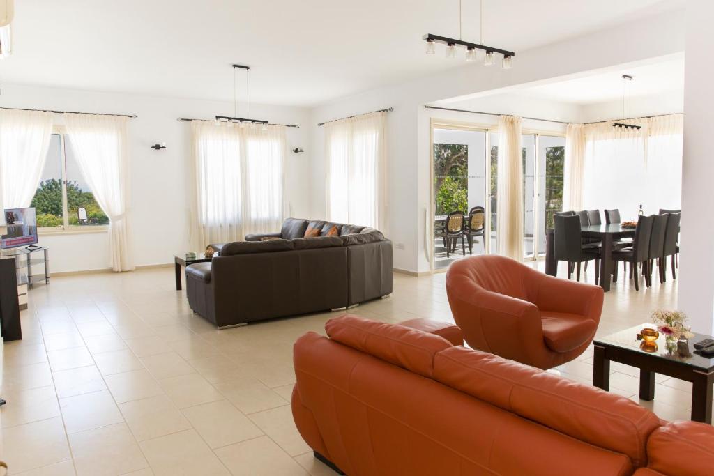 a living room with a couch and chairs and a table at Eliofos Luxury Villa in Polis Chrysochous