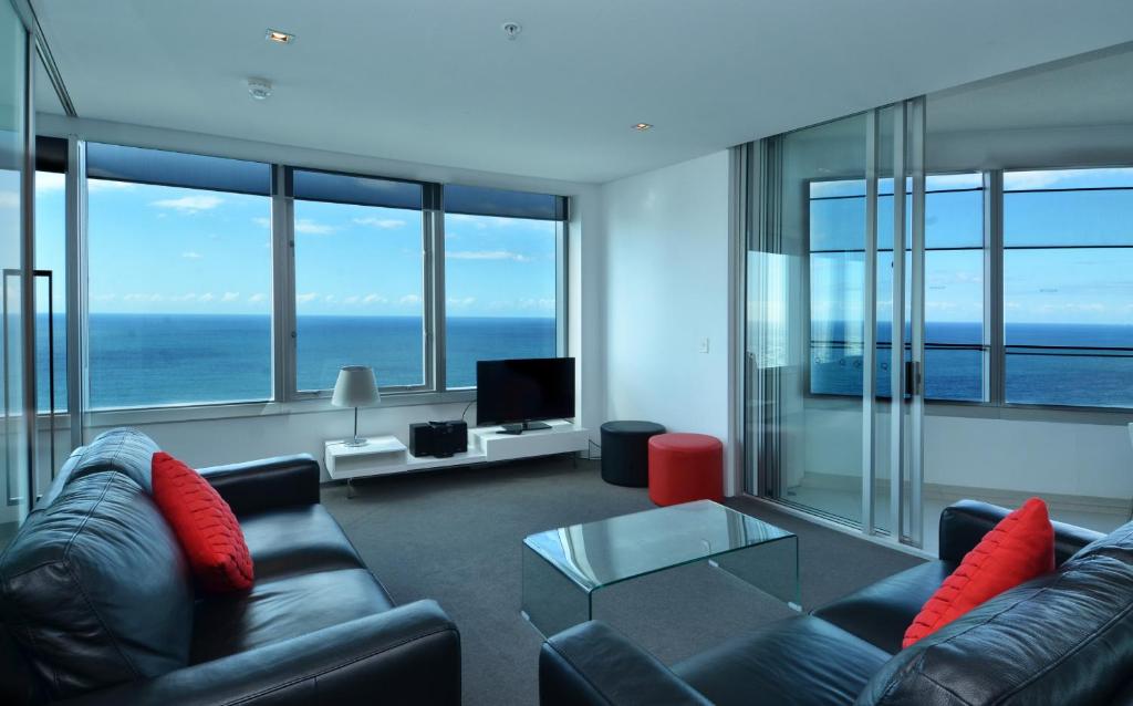 ein Wohnzimmer mit Sofa und Tisch in der Unterkunft HR Surfers Paradise - Apartment 4204 in Gold Coast