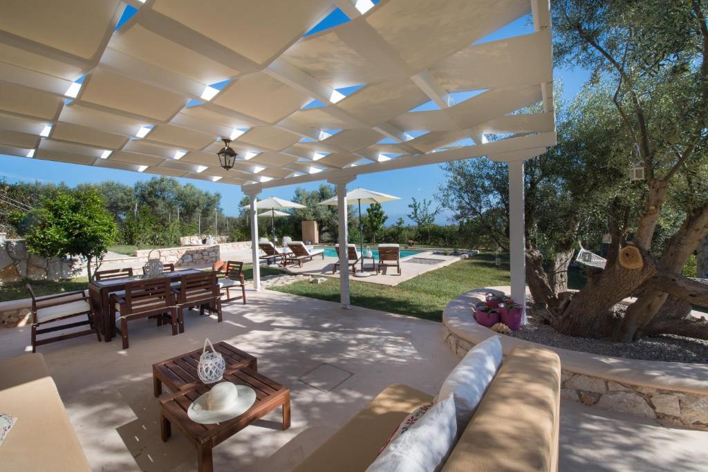 een patio met een witte pergola bij Villa Marilia in Tsoukaladhes