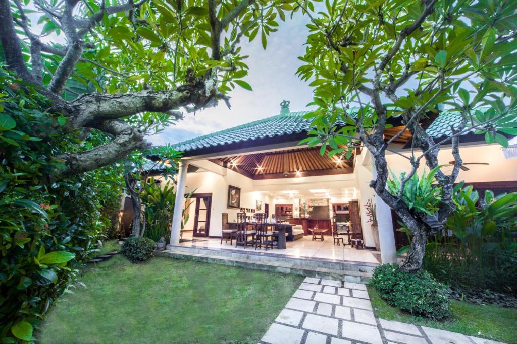 a house with a garden and a patio at Villa Frangipani in Sanur