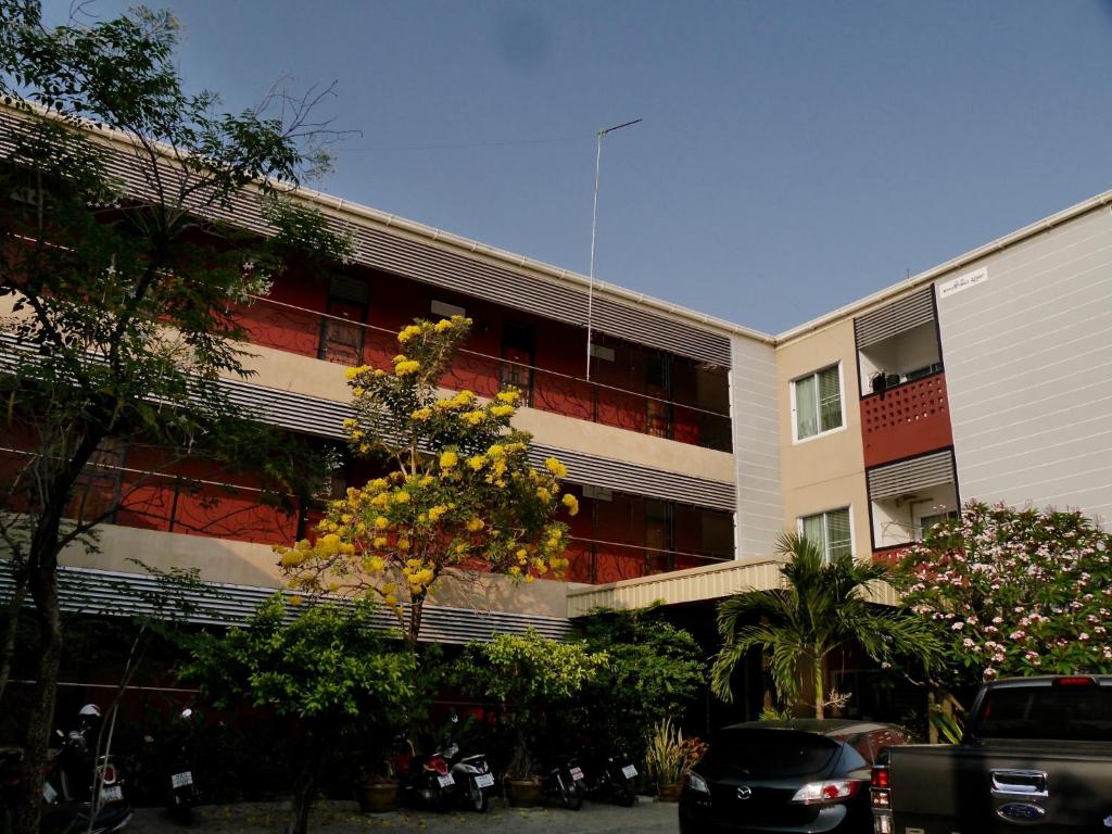 un edificio con un árbol delante de él en Pakdee House, en Udon Thani