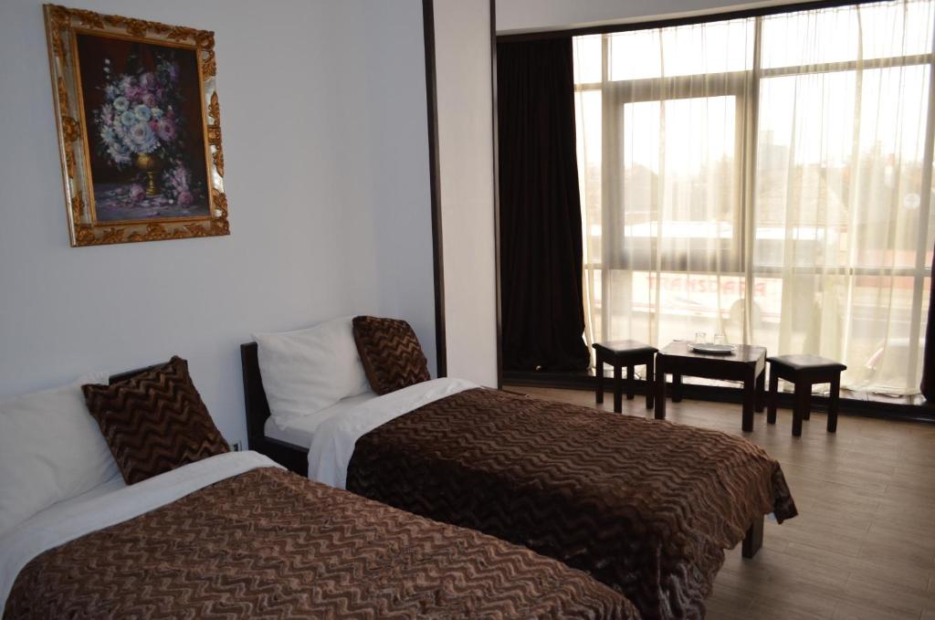 um quarto de hotel com duas camas e um sofá e uma janela em Hotel Taverna Pecicana em Pecica Veche
