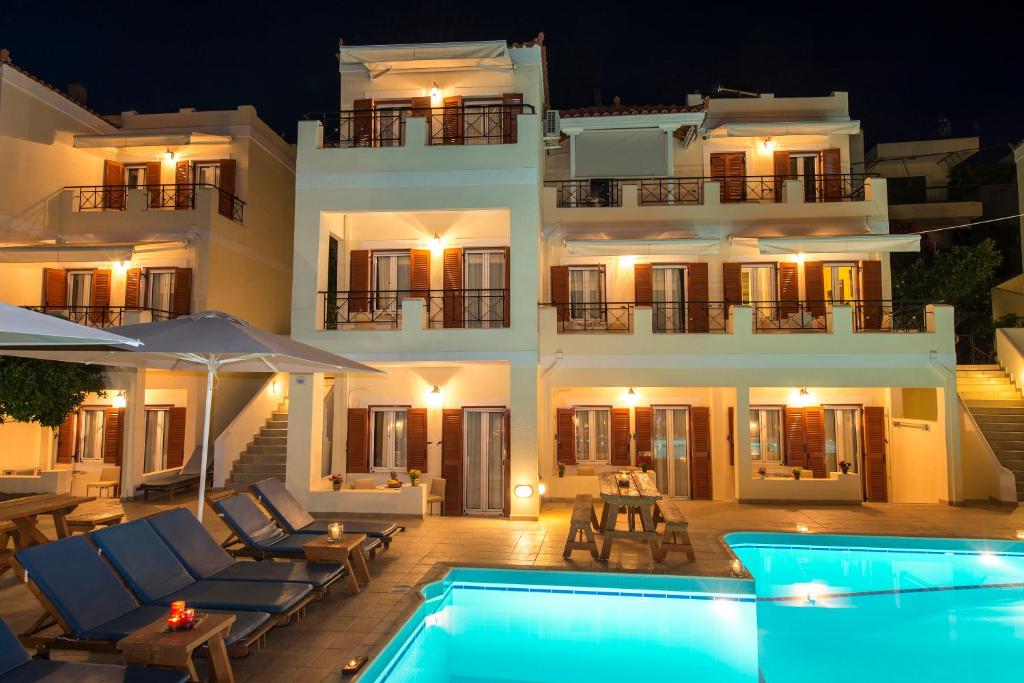 a villa with a swimming pool at night at Kostis Villas in Poros