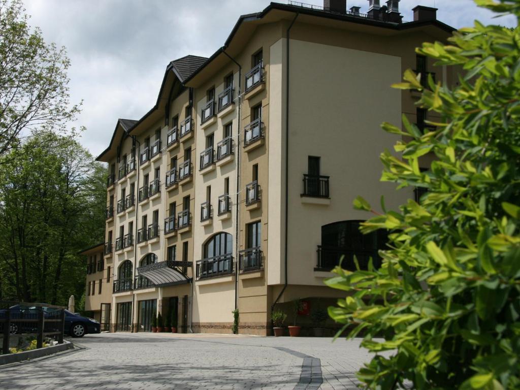 a large white building with a lot of windows at Hotel Elbrus Spa & Wellness in Szczyrk