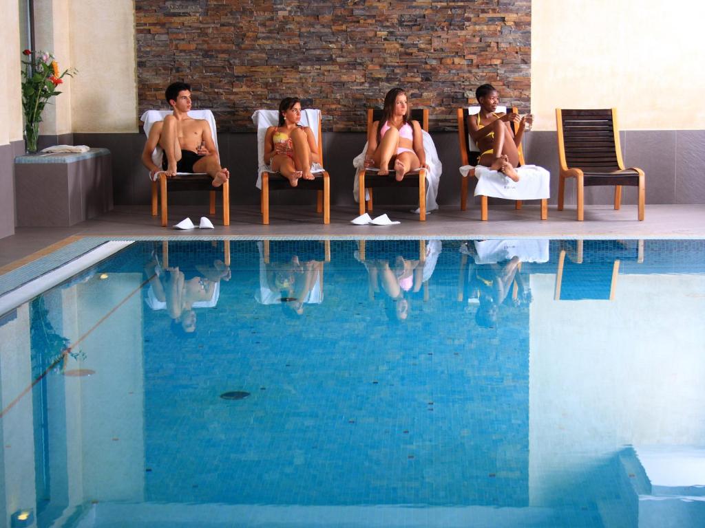 a row of people sitting on top of a swimming pool at Hotel Elbrus Spa & Wellness in Szczyrk