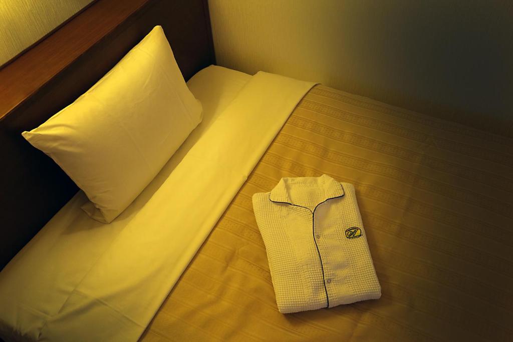 Postel nebo postele na pokoji v ubytování Kumegawa Wing Hotel