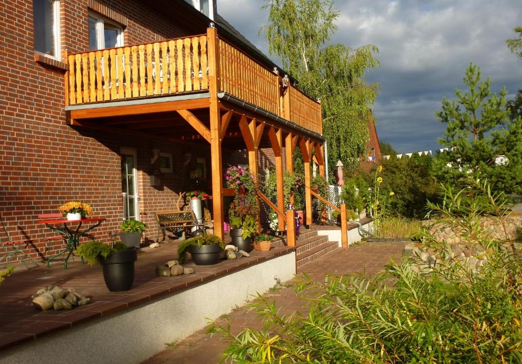 een houten terras aan de zijkant van een gebouw bij Aparthotel " Zur Müritz" in Rechlin