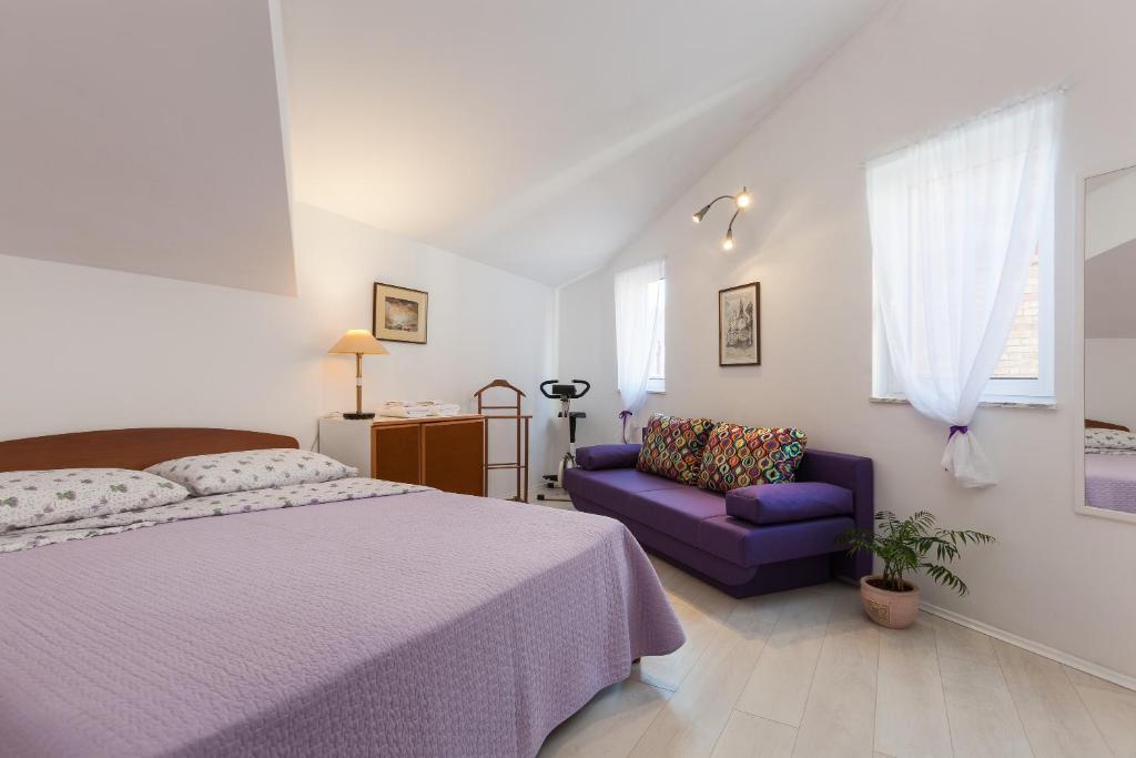 a bedroom with a bed and a purple couch at Split Old Town Apartment in Split
